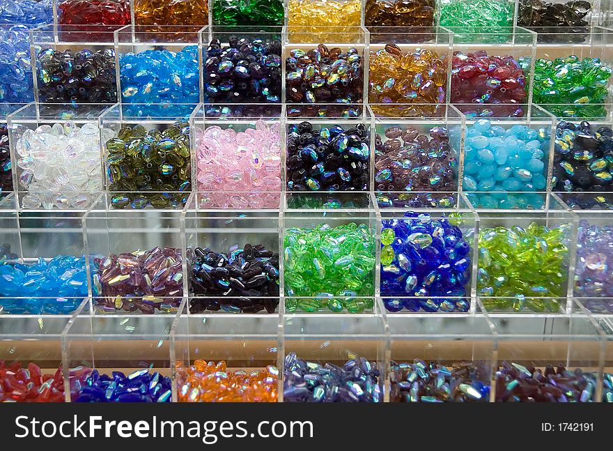 Plastic trays containing different types of plastic beads.