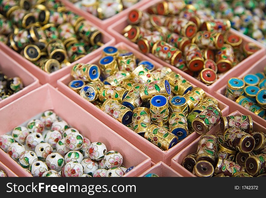 Arrayed boxes containing different types of chinese beads. Narrow DoF.