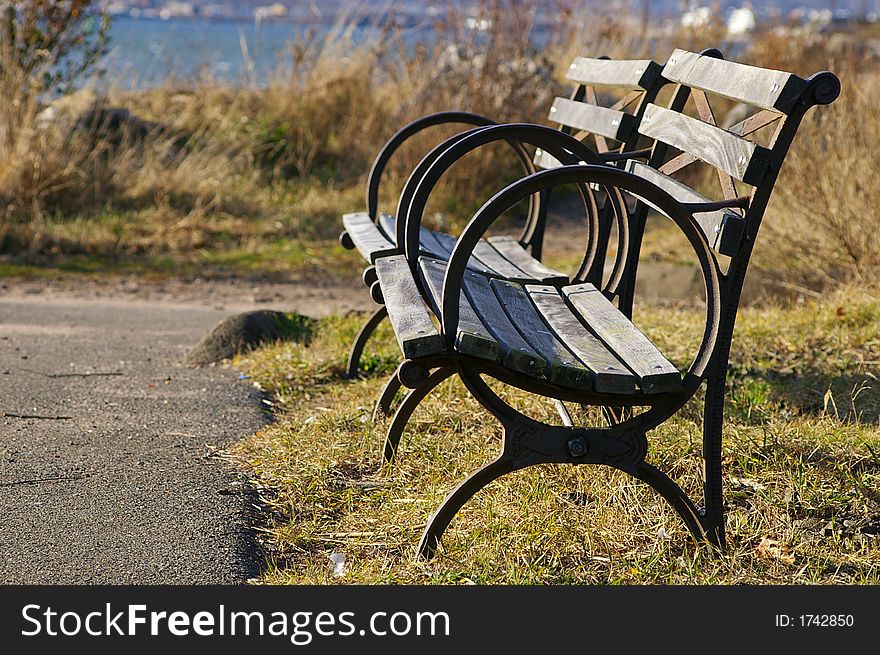 Bench na path on the coast of New Haven, CT, with round armrests. Bench na path on the coast of New Haven, CT, with round armrests