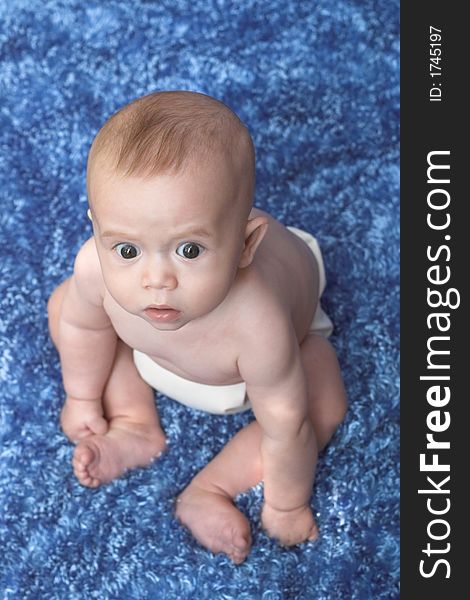 Image of sitting baby, looking up at the camera. Image of sitting baby, looking up at the camera