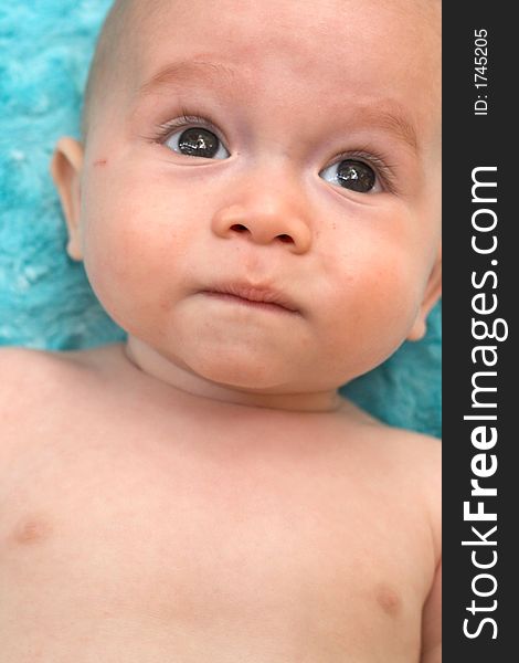 Image of a beautiful baby boy lying on a blue blanket. Image of a beautiful baby boy lying on a blue blanket