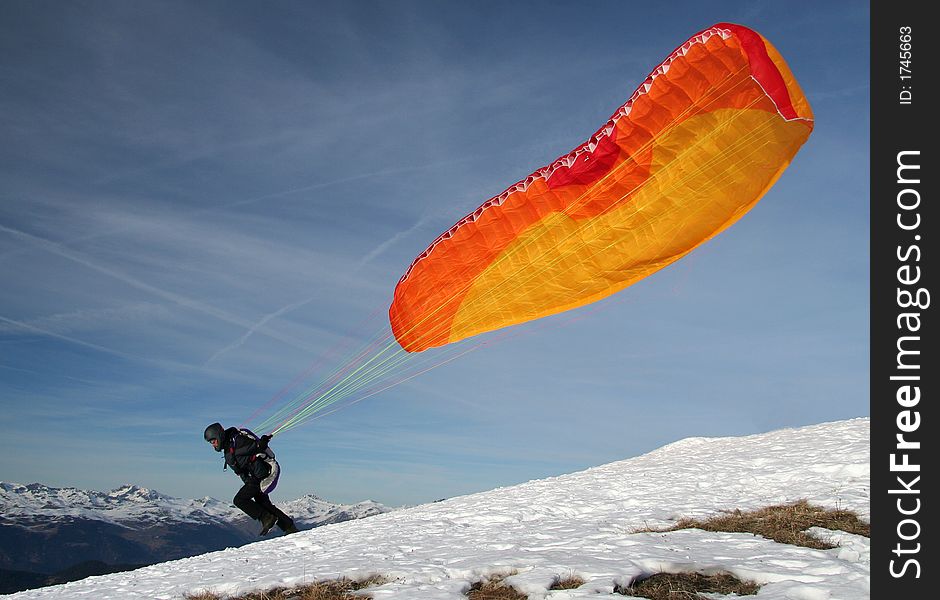 Paraglider takes off from the mountain to fly over the valley