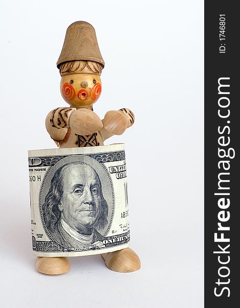 US one hundred dollar bill rolled around a small wooden doll as a garment. US one hundred dollar bill rolled around a small wooden doll as a garment