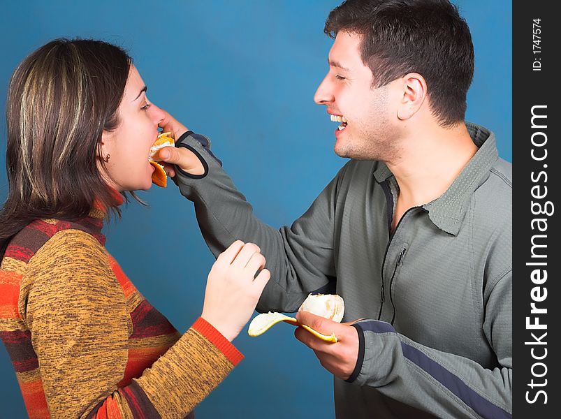 Young couple eat an orange. Young couple eat an orange