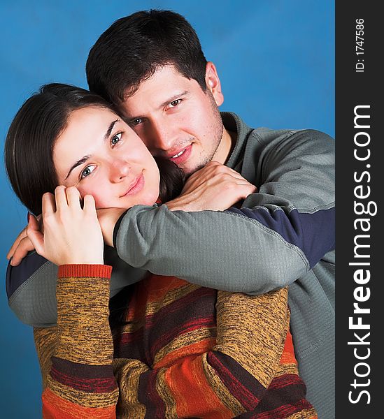 Young happy couple smiling on blue background