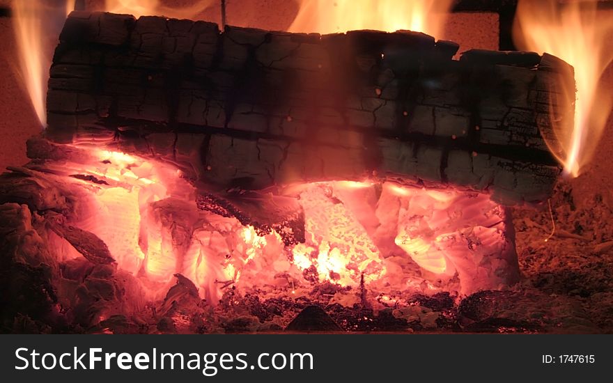 Log burning inside of a wood stove with a blazing fire. Log burning inside of a wood stove with a blazing fire