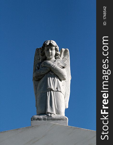 Angel with a cross on top of a tomb