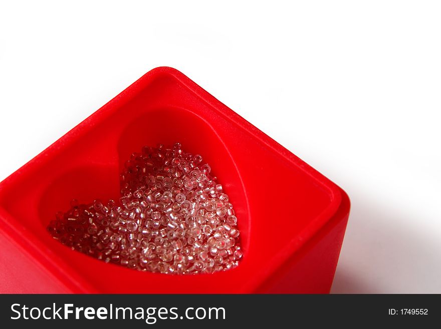 Closeup of red heart-shaped box with white glass beads, on white background and with copy space. Closeup of red heart-shaped box with white glass beads, on white background and with copy space