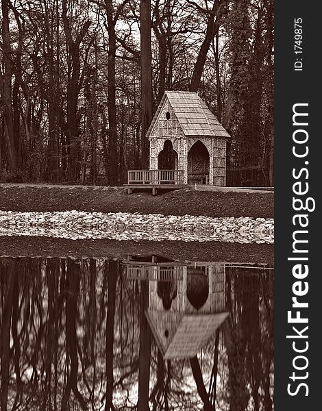 Gazebo in sepia with reflection in water