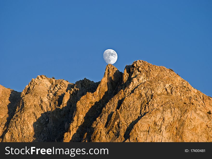 Moon balanced on a mountain peak. Moon balanced on a mountain peak.