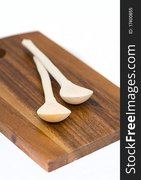 Two wooden spoons on a cutting board