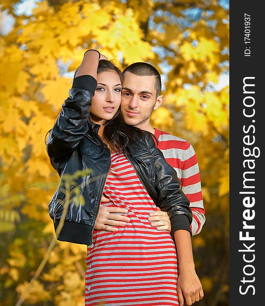 Couple of young lovers are walking in the autumn park. Couple of young lovers are walking in the autumn park