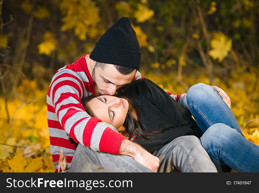 Couple of young lovers are walking in the autumn park. Couple of young lovers are walking in the autumn park