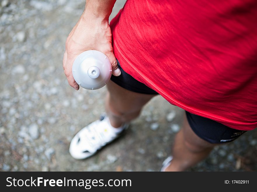 Mountain biking in a forest - bikers on a forest biking trail (shallow DOF, focus on the bike wheel in the foreground)