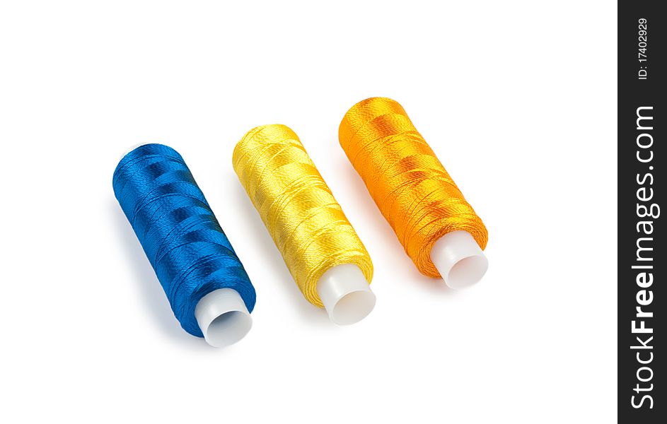 Blue, yellow and orange spools on a white background