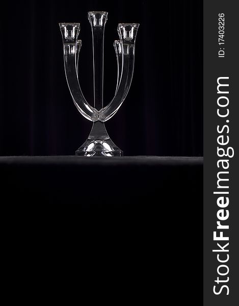 Glass candle holder on a dark background.