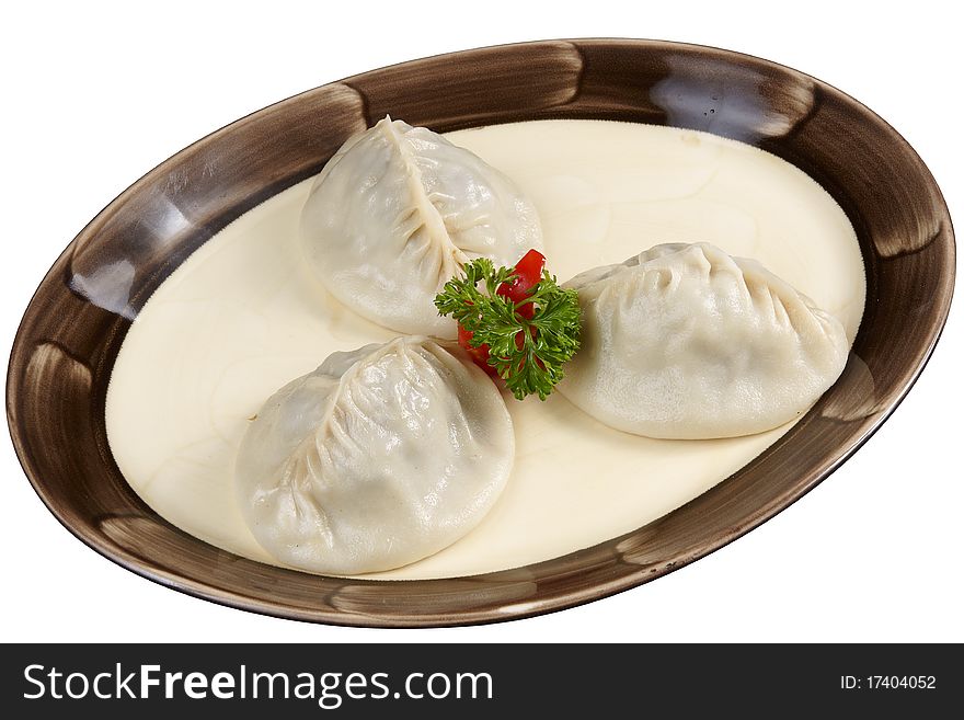 Oriental meat dumplings, parsley red sweet pepper and  on white plate with brown band