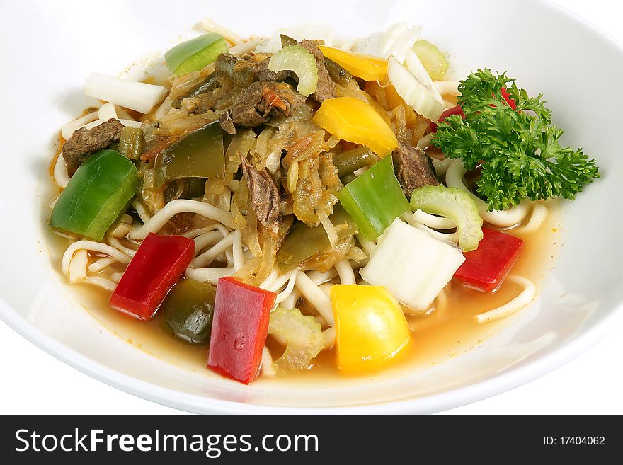 Beef stirfry with noodles and mixed vegetables: sweet pepper, onion, parsley, summer radish, carrot, and sauce