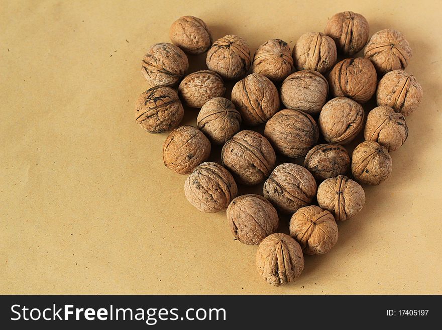 Nuts in the shape of a heart on the isolated yellow background