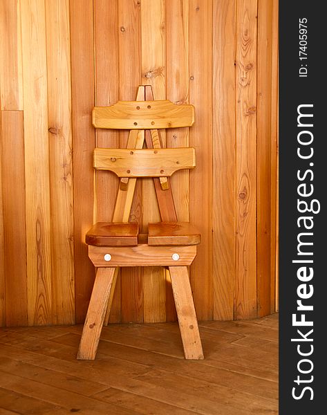 Wooden chair in front of a wood tiled wall