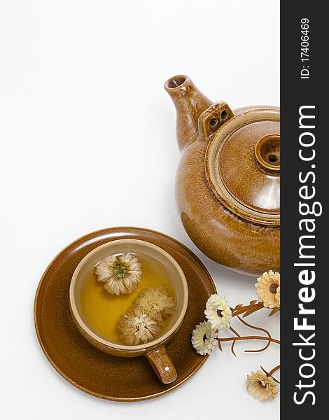 A cup of chrysanthemum tea and wood teapot mat, on a white background. A cup of chrysanthemum tea and wood teapot mat, on a white background