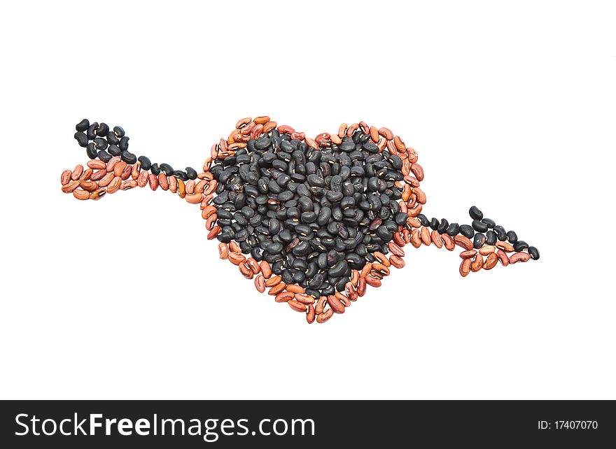 Black beans and yellow beans seed are arranged as heart shape with the arrow strike through isolated on white background. Black beans and yellow beans seed are arranged as heart shape with the arrow strike through isolated on white background.