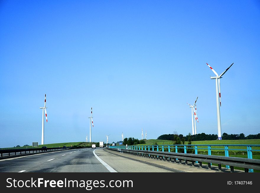An image of Highway and wind turbines in the foreground