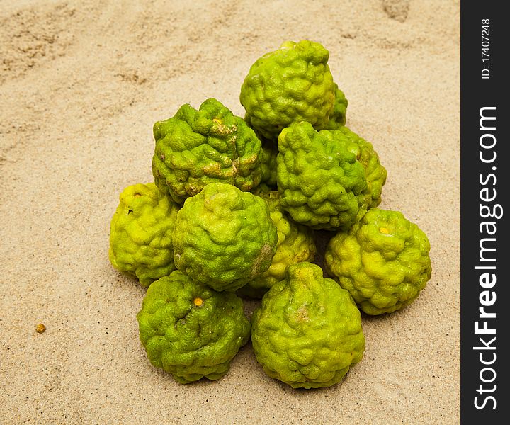 Green limes on sand are herps for spa beauty and food ingredient. Green limes on sand are herps for spa beauty and food ingredient.