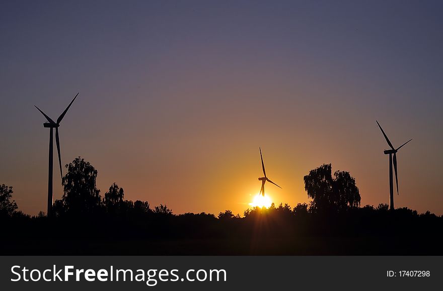 Wind turbine during sunset in summer time