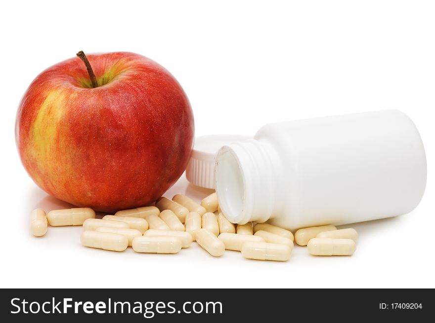 Apple with pills isolated on white background. Apple with pills isolated on white background