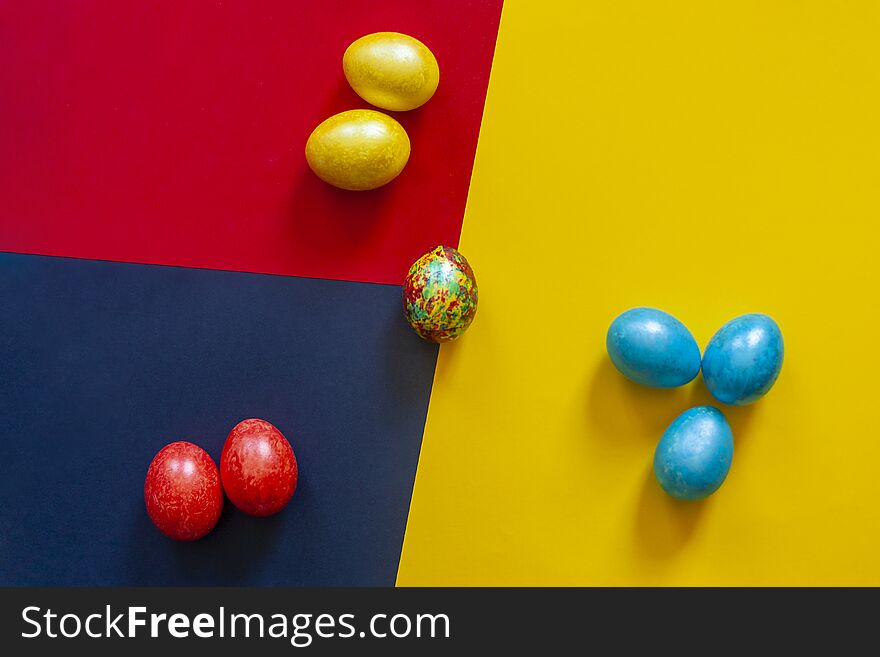 Colorful easter eggs on the bright multicolored background. View from above. Top view. Flat lay image. Colorful easter eggs on the bright multicolored background. View from above. Top view. Flat lay image