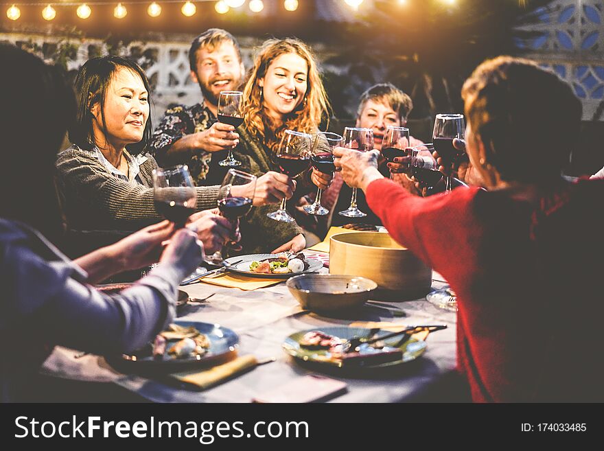 Happy Family Eating And Drinking Wine At Barbecue Dinner Outdoor - Multiracial Mature And Young People Having Fun At Bbq Sunday