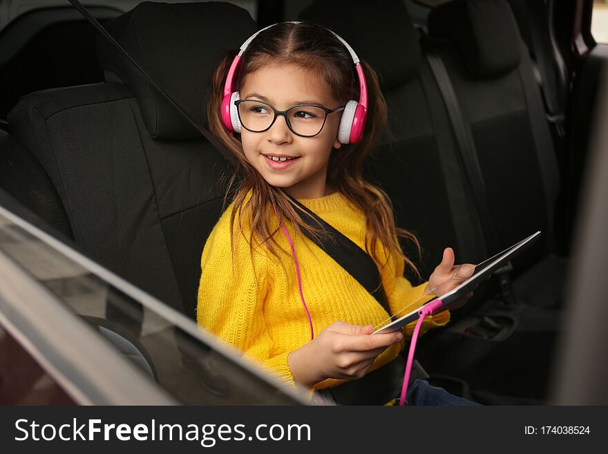 Cute little girl listening to audiobook in car. Cute little girl listening to audiobook in car