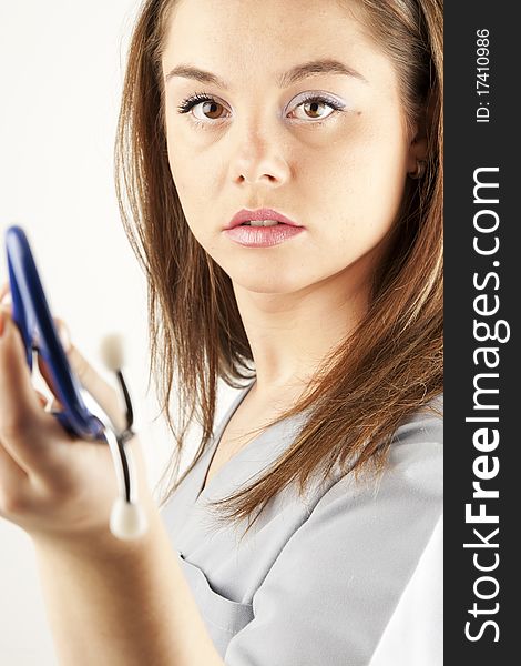 Young woman doctor or nurse holding a stethoscope wearing scrubs