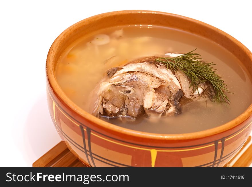 Fish soup in a clay plate on a white background