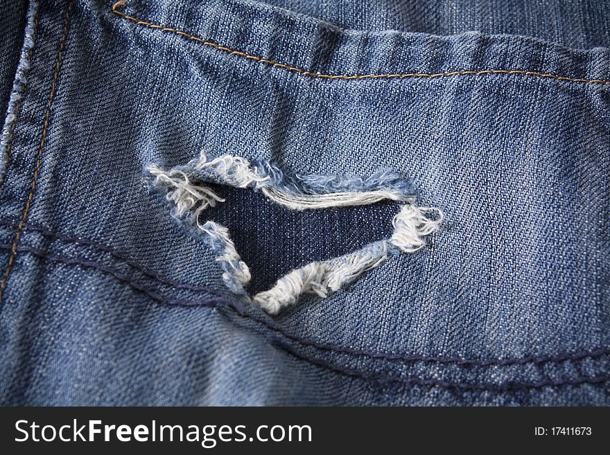 Pair of old jeans with frayed heart shaped rip. Pair of old jeans with frayed heart shaped rip