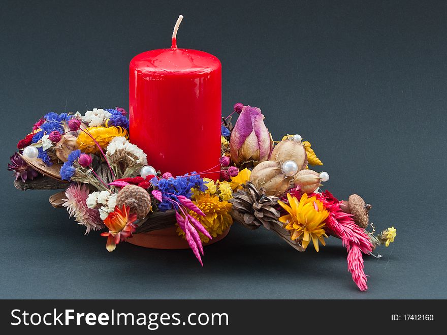 Decoration of dry flowers with a red candle on black background. Decoration of dry flowers with a red candle on black background.