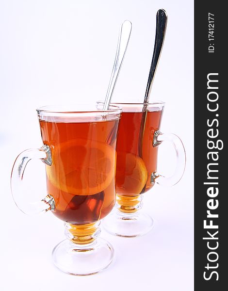 Two glasses of tea with lemon on white background