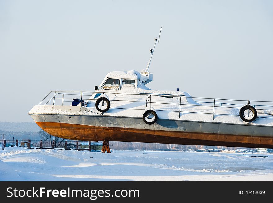 Snow-covered boat on winter mooring. Snow-covered boat on winter mooring