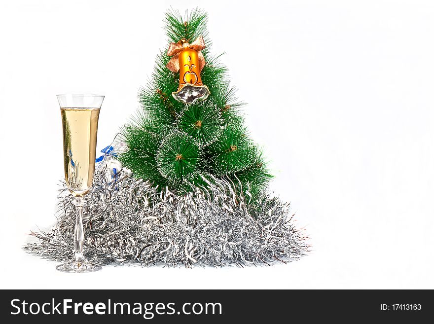 Christmas tree decorated with toys, tinsel and a glass of champagne with a symbol of New Year celebrations