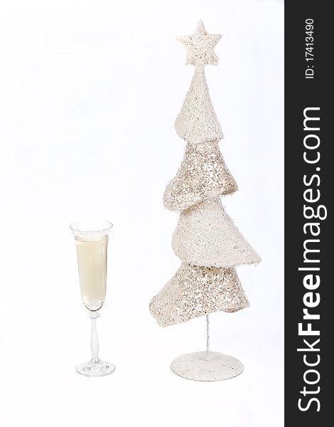 White Christmas tree and a glass of champagne on a white background symbol of Christmas and New Year