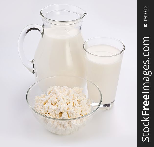 Jar and glass with milk and bowl with cottage cheese. Isolated on a white. Jar and glass with milk and bowl with cottage cheese. Isolated on a white.