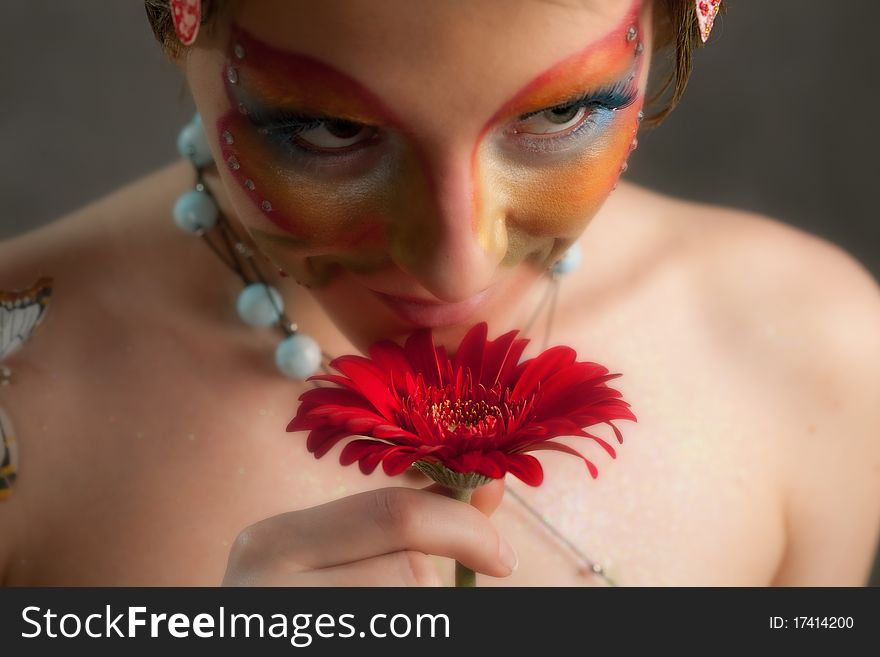 Girl with butterfly make-up on face and flower. Girl with butterfly make-up on face and flower