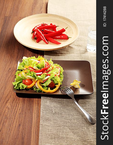 Food theme: fresh vegetable salad and red peppers on a table. Food theme: fresh vegetable salad and red peppers on a table.