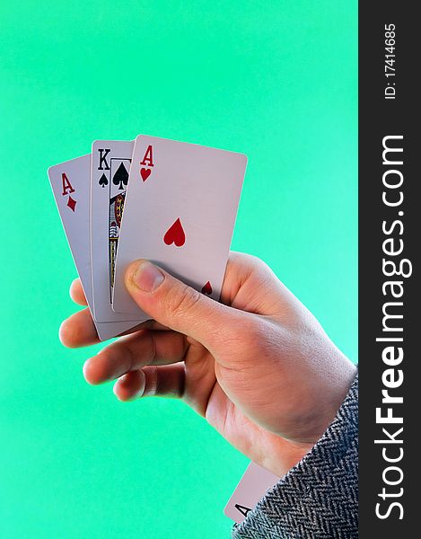 A man holding a playing card against a green background. A man holding a playing card against a green background