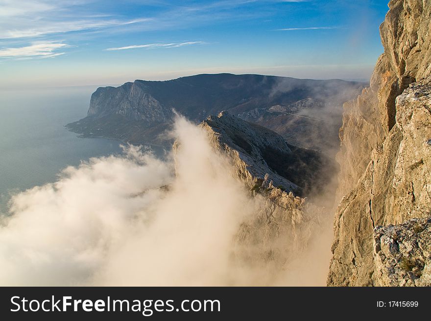 Scenic ridge facing the sea. Clouds rise to the top of the mountain. Scenic ridge facing the sea. Clouds rise to the top of the mountain