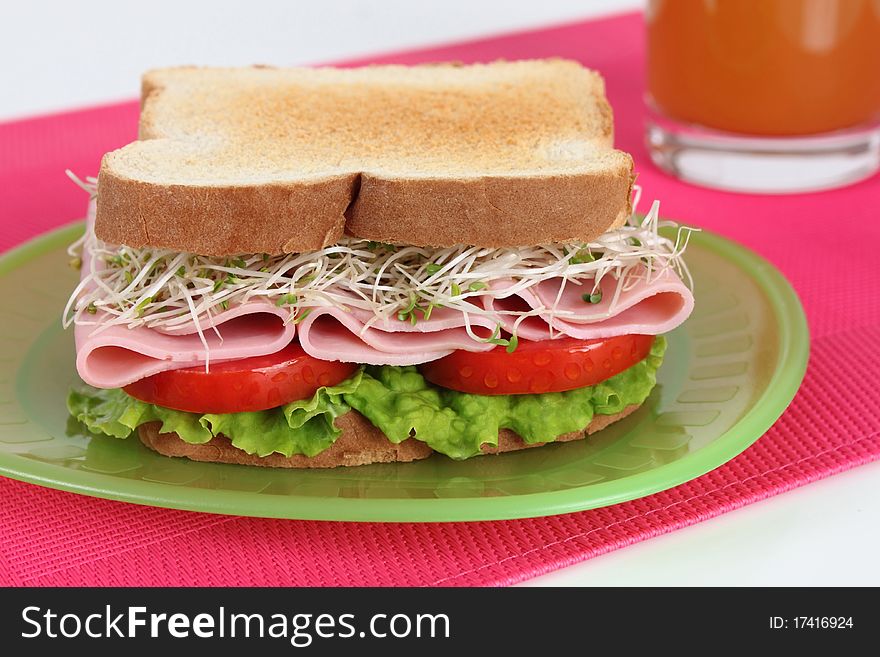Ham sandwich with alfalfa, tomato and lettuce