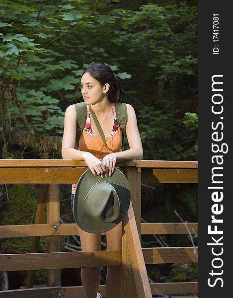 Young woman hiking in summer near waterfall.