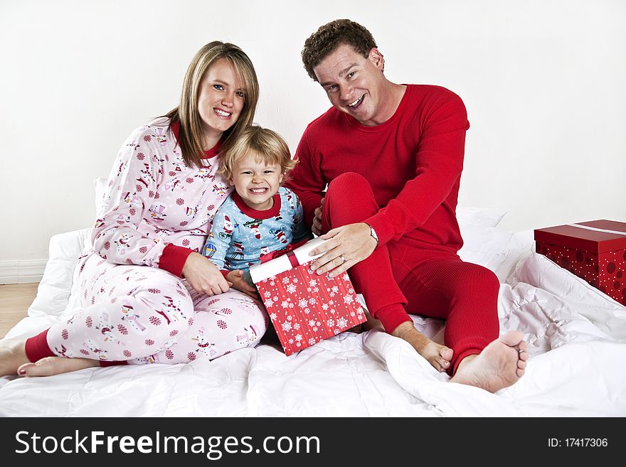 A family in bed wearing pajamas with presents. Christmas morning. A family in bed wearing pajamas with presents. Christmas morning.