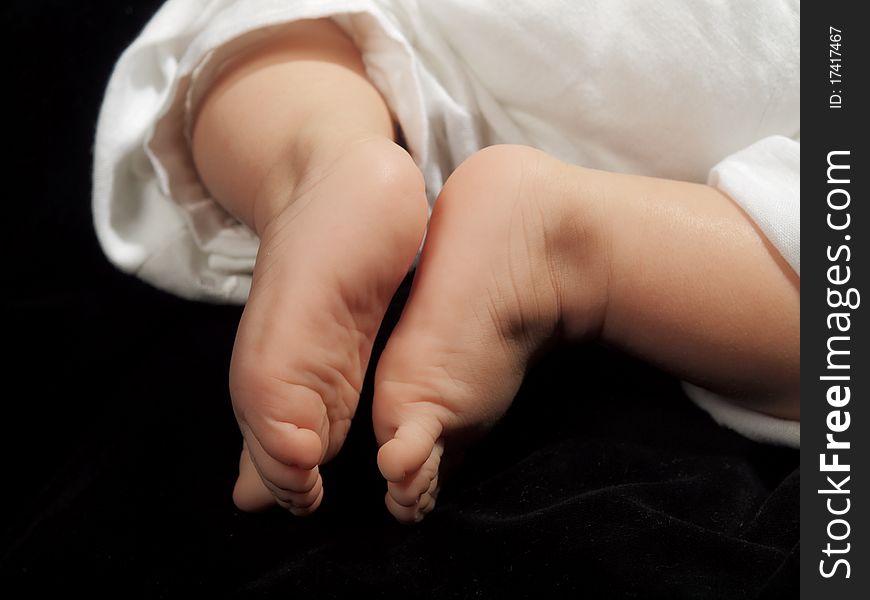Little babies feet on a black isolated background